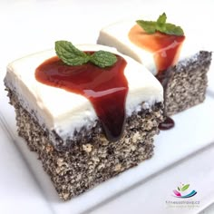 two pieces of cake on a white plate with chocolate sauce and green leafy garnish