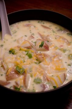 a close up of a bowl of soup on a table with a spoon in it