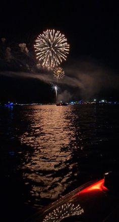 fireworks are lit up over the water at night