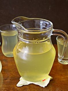 a pitcher of lemonade sitting on top of a wooden table