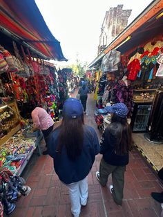 people are walking through an outdoor market area