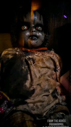 a creepy doll is sitting in the dark