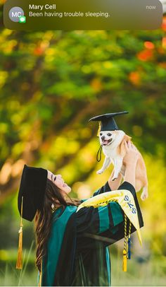 a woman holding a small dog in her graduation cap and gown while wearing a tassel