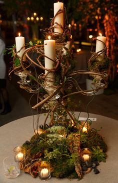 a table with candles and moss on it