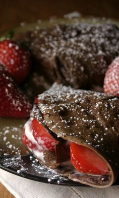 a chocolate cake with strawberries and powdered sugar