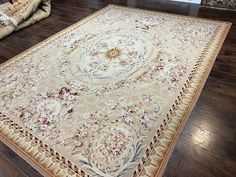 a large area rug on the floor in a living room with wood floors and furniture