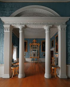 an ornate room with columns and blue walls