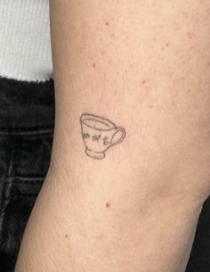 a small tattoo on the leg of a person with a coffee cup tattooed on it