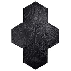 a black hexagonal object with intricate designs on it