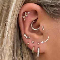 a woman's ear with three piercings on it and one behind the ear