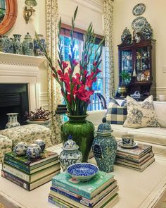 a living room filled with lots of books and vases on top of a table