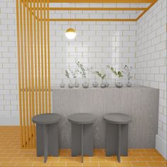 three stools in front of a tiled wall with plants on the top and below