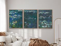 three paintings hanging on the wall above a bed