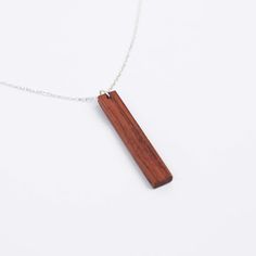 A beautiful and unique combination of silver and Real Rose Wood makes this our most preferred necklace. *Made to order, upon request, photos will be shared with the buyer when the necklace is ready. After the buyer's approval, the package is transferred to the carrier. Product details: - Pendant dimensions: 44mm x 6mm x 3mm - Available chain lengths: 16" or 18" (model is wearing a 16"). All chains come with a 2" extension chain for length versatility. - Material: Rosewood and Silver - This neckl Monogram Wood Necklace, Wood Anniversary, Wood Anniversary Gift, Satin Noir, Real Rose, Anniversary Gift For Wife, 5th Anniversary, Wood Bar, Wood Necklace