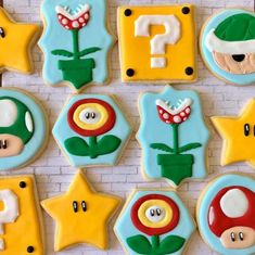 decorated cookies are arranged in the shape of mario's letters and symbols on a white brick wall