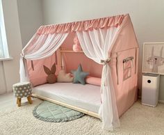 a child's bed with pink and white drapes on the top, curtains at the bottom