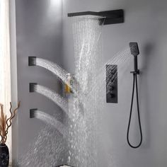 the shower head is spraying water from it's spout and hoses in this modern bathroom