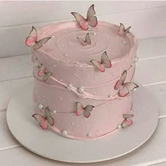 a three layer pink cake with butterflies on it