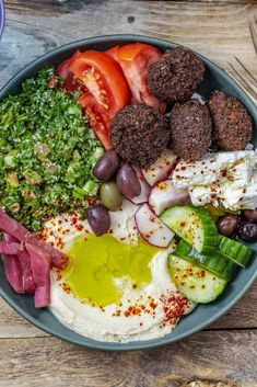 mediterranean falafel bowls with hummus, salad and feta on a wooden table