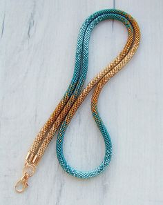 a blue and gold colored leash on a white wooden surface