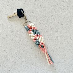 a keychain made out of beads on a white surface with a black clip