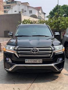 the front end of a black suv parked in a driveway