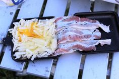 some food is laying out on a picnic table with it's tray full of meat and cheese