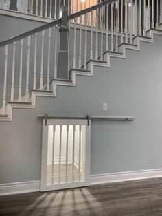 an empty room with white railings and stairs