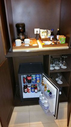 the small refrigerator is stocked with drinks and condiments