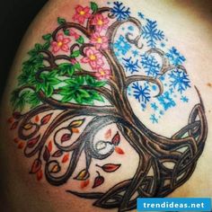 a woman's shoulder with an artistic tattoo design on it and flowers in the center