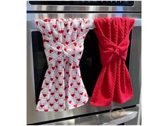 two towels hanging on the side of an oven