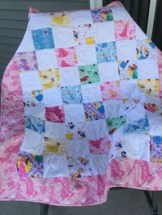 a pink and white quilt sitting on top of a chair