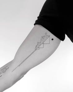 a person with a tattoo on their arm that has an arrow in the shape of a triangle