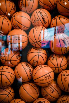 many basketballs are stacked together in a pile