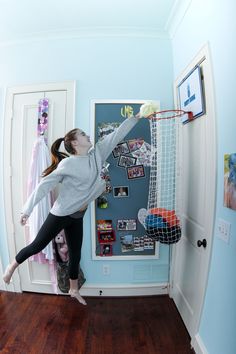 a girl is jumping in the air to catch a frisbee with her hands