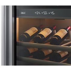 several bottles of wine are sitting in an open refrigerator with timers on the door