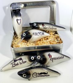 three fish in a metal box with the word groom written on them and two spoons next to it