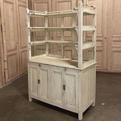 an old white cabinet with shelves and cupboard doors