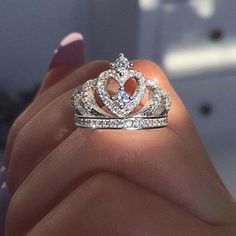 a woman's hand holding a diamond ring