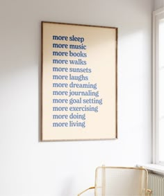 a chair sitting in front of a window next to a framed poster on the wall