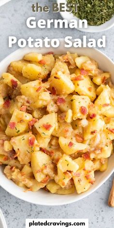 the best german potato salad in a white bowl on a table with spices and herbs