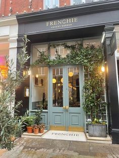 the front entrance to frenchie bistro with potted plants on the sidewalk outside