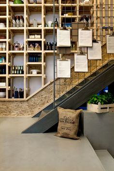 the shelves are filled with bottles and other items on display in front of an escalator