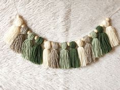 a green and white tasselled necklace with wooden beads