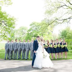 a bride and groom kissing in front of their wedding party