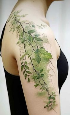 a woman's shoulder with green leaves on the back of her arm and chest