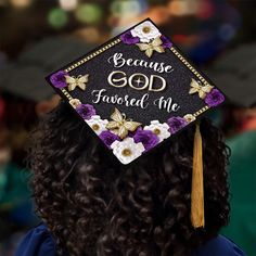 a woman wearing a graduation cap with flowers on it and the words because god loved me