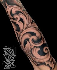 the arm is covered in black and grey ink with swirls on it, as well as