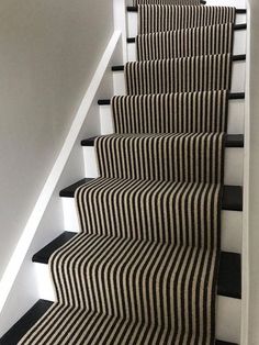 black and white striped carpeted stairs leading up to the second floor