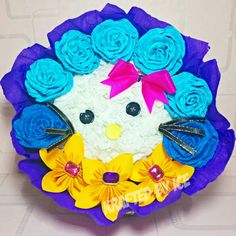 a cake that looks like a cat with flowers on it's head and eyes